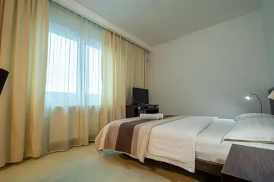 a bedroom with a bed and a large window at Hotel Golf Luxury in Kruševac