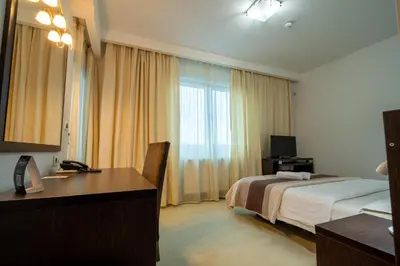 a hotel room with a bed and a desk and a window at Hotel Golf Luxury in Kruševac