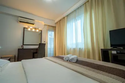 a hotel room with a bed with two towels at Hotel Golf Luxury in Kruševac
