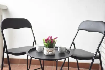two chairs and a table with flowers on it at Apartmansko naselje JEZERO in Vrnjačka Banja