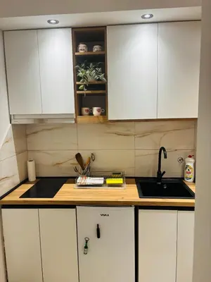a kitchen with white cabinets and a sink at Apartmansko naselje JEZERO in Vrnjačka Banja