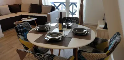 a table with plates and dishes on it in a living room at Apartman Four Seasons Kopaonik in Kopaonik