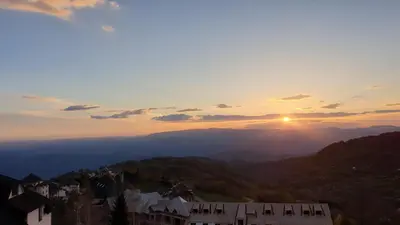 a view of the sun setting over the mountains at Apartman Four Seasons Kopaonik in Kopaonik