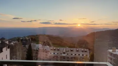 a view of the sun setting over a mountain at Apartman Four Seasons Kopaonik in Kopaonik