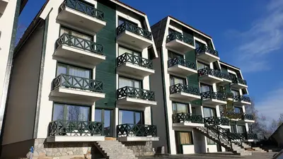 a green and white building with balconies on it at Apartman Four Seasons Kopaonik in Kopaonik