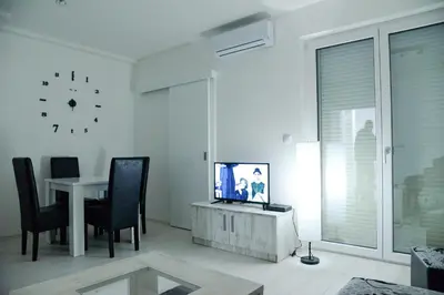 a living room with a tv and a table with chairs at BEST Apartments in Paraćin