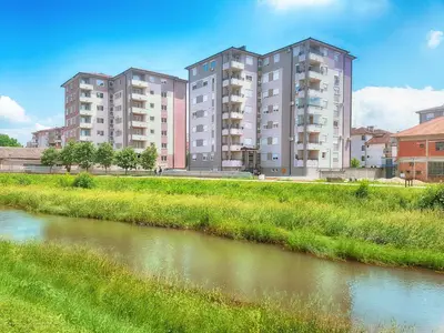 two tall apartment buildings next to a river at BEST Apartments in Paraćin