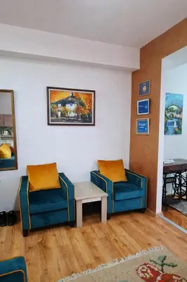 two chairs and a table in a living room at Apartman DUNJA sa terasom in Vranje