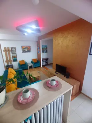 a living room with a table with two plates on it at Apartman DUNJA sa terasom in Vranje