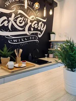 a kitchen with a sink and a wall with writing at Apartment Take a breath in Vrnjačka Banja