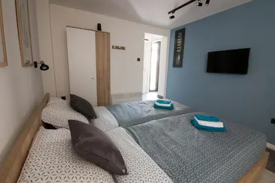 a bedroom with two beds and a flat screen tv at Sunrise Apartments in Niš