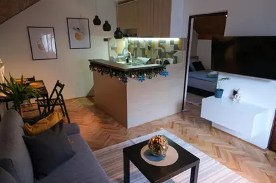 a living room with a kitchen with a sink and a table at Sunrise Apartments in Niš