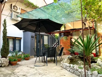 a table and chairs under an umbrella in front of a house at Sunrise Apartments in Niš