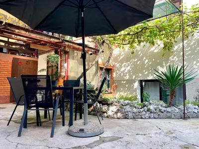 a table and chairs with an umbrella in front of a house at Sunrise Apartments in Niš