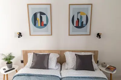 a bedroom with two beds and two pictures on the wall at Sunrise Apartments in Niš