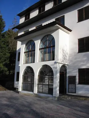 a white building with large windows on it at Villa Kostic Kopaonik in Kopaonik