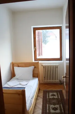 a small bedroom with a bed and a window at Villa Kostic Kopaonik in Kopaonik