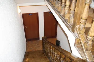 a stairway with three wooden doors in a building at Villa Kostic Kopaonik in Kopaonik