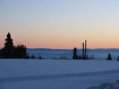 a snow covered field with a sunset in the background at Villa Kostic Kopaonik in Kopaonik