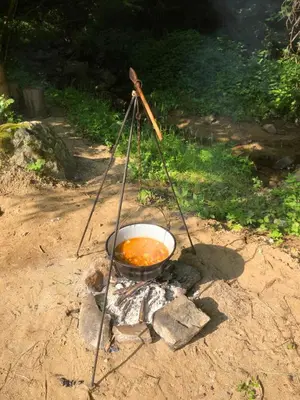 a pot of food sitting on top of a fire at Vila Idila in Crni Vrh