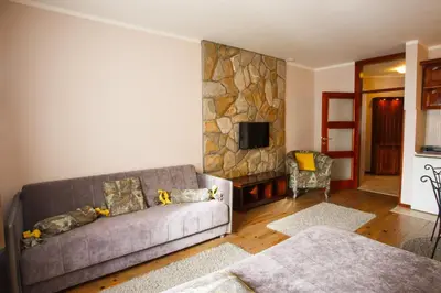 a living room with a couch and a stone wall at Vila Trag in Kopaonik