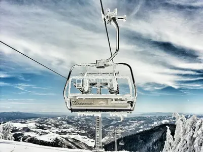 a ski lift on top of a snow covered mountain at Vila Trag in Kopaonik