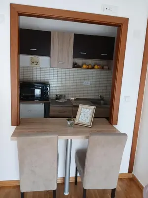 a kitchen with a table with two chairs and a microwave at Apartman Jovanović in Vrnjačka Banja