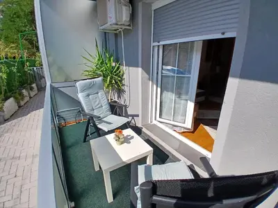 a patio with a table and chairs on a balcony at Apartman Jovanović in Vrnjačka Banja