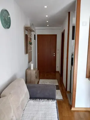 a living room with a couch and a clock on the wall at Apartman Jovanović in Vrnjačka Banja