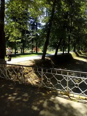 a person walking in a park behind a fence at Агни in Vrnjačka Banja