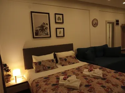 a bedroom with a bed with towels and a couch at Milmari L4 in Kopaonik