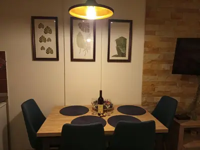 a dining room table with chairs and a bottle of wine at Milmari L4 in Kopaonik