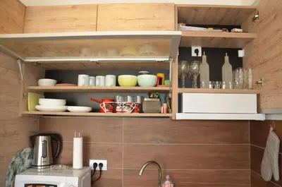 a kitchen with wooden walls and shelves with dishes and bottles at Milmari L4 in Kopaonik