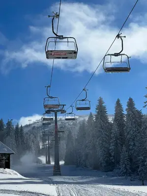 a ski lift with two chairs in the snow at Milmari L4 in Kopaonik