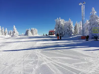 a group of people on a snow covered ski slope at Milmari L4 in Kopaonik