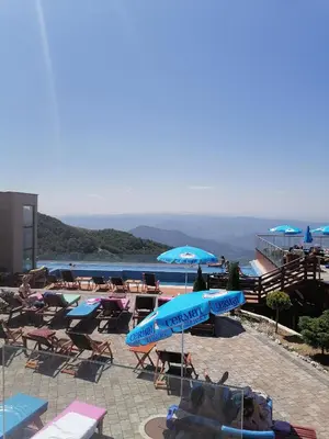 a resort with a pool with chairs and umbrellas at Milmari L4 in Kopaonik