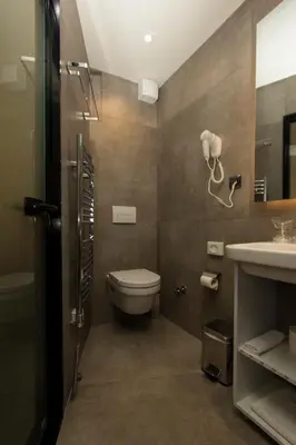 a bathroom with a toilet and a sink at BOUTIQUE 25h by Eva stay 018 in Niš