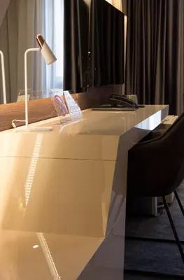 a white desk with a lamp and a chair at BOUTIQUE 25h by Eva stay 018 in Niš