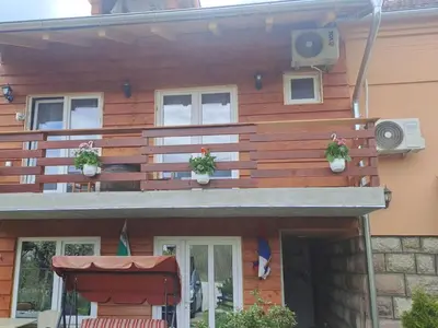 a wooden house with potted plants on the balcony at VILA BOJANA in Inovo