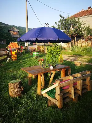 a picnic table with a blue umbrella and a bench at VILA BOJANA in Inovo