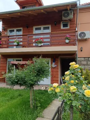 a house with a balcony and flowers in front of it at VILA BOJANA in Inovo