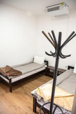 a room with two beds and a fan at Apartments Kuca Aleksic in Niš