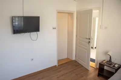 a living room with a flat screen tv on a wall at Apartments Kuca Aleksic in Niš