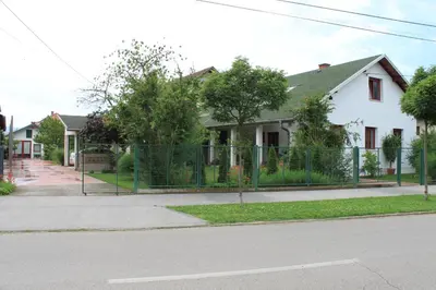 a fence in front of a white house at Boulevard Garden House - Free and save parking in the locked yard in Ćuprija