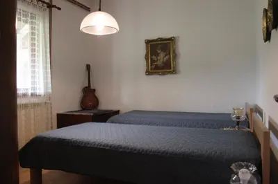 a bedroom with two beds and a guitar on the wall at Boulevard Garden House - Free and save parking in the locked yard in Ćuprija