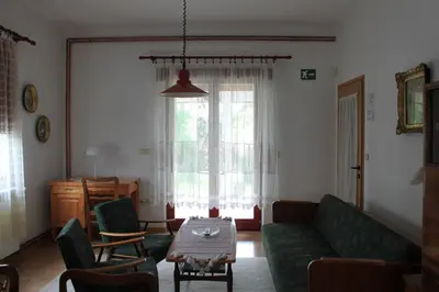 a living room with a green couch and a table at Boulevard Garden House - Free and save parking in the locked yard in Ćuprija