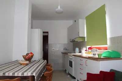 a kitchen with a table and a green and white at Boulevard Garden House - Free and save parking in the locked yard in Ćuprija