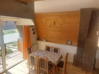 a dining room with a table and chairs and a window at Vili Bilyana in Crni Vrh
