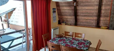 a table and chairs in a room with a window at Vili Bilyana in Crni Vrh