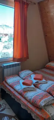 two beds in a room with a window at Vili Bilyana in Crni Vrh